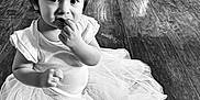 Piper joined the competition — help win amazing prizes! child, toddler, baby, floor, wood_floor, tutu, clothing, sitting, cute, portrait, indoor, black_and_white, hair, pony_tail, hand, face, curious, expression, home, furniture