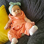 Harmony joined the competition — help win amazing prizes! baby, black_couch, child, comfortable, cute, expression, fabric, furniture, headband, indoor, infant, peach_outfit, portrait, quilted_couch, relaxed, seated, small_hands, sock, soft_lighting, yellow_pillow