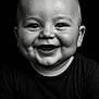 baby, child, smiling, black_and_white, portrait, water_droplets, face, happy, cute, eyes, skin, closeup, head, infant, expression, clothing, black_shirt, chubby_cheeks, studio, background
