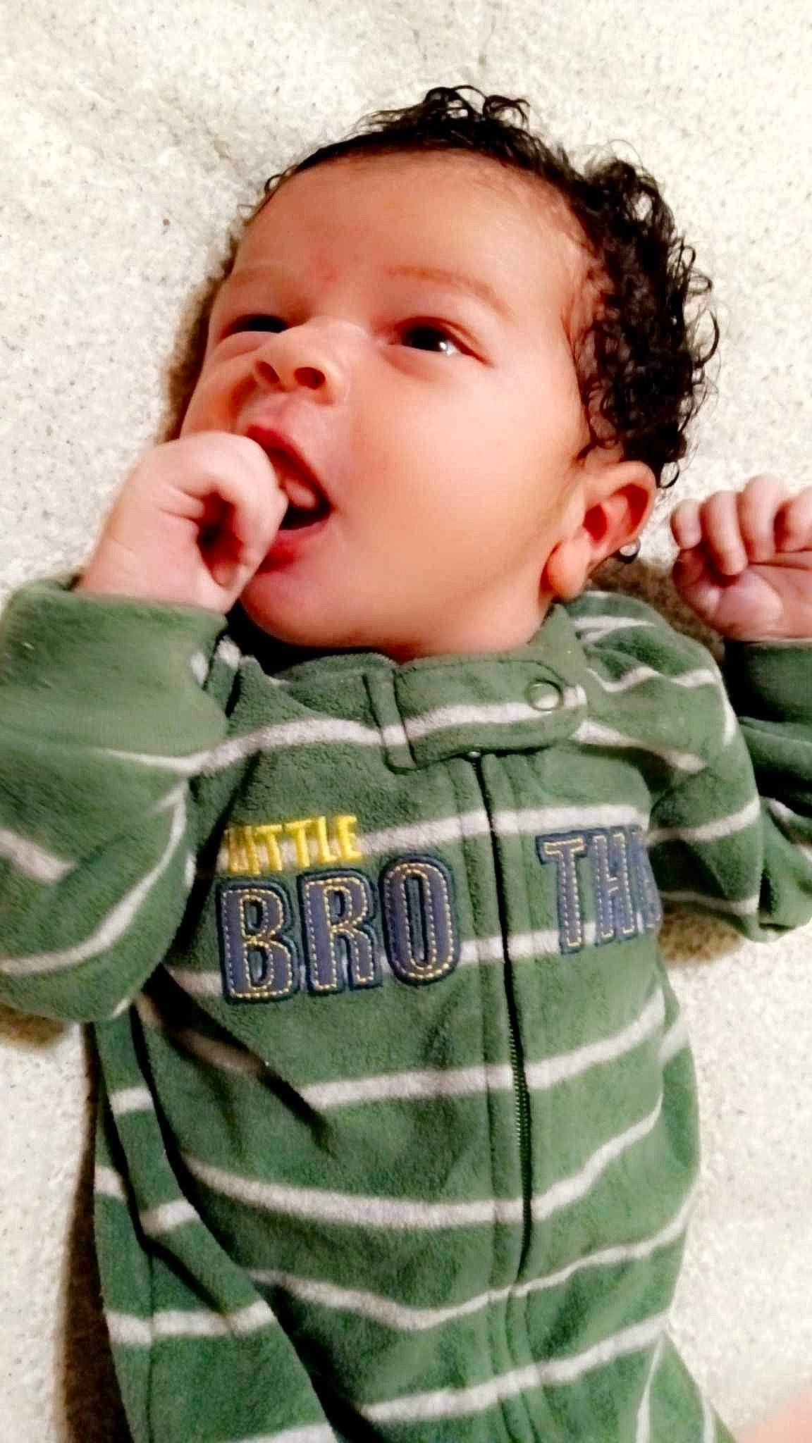 Camden is registered to the contest to win money with this photo: baby, baby_toddler_clothing, camouflage, cheek, chin, eye, face, finger, gesture, happy, military_camouflage, mouth, nose, outerwear, person, photograph, product, skin, sleeve, textile