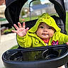 Elijah joined the competition — help win amazing prizes! baby, child, stroller, hooded_jacket, green_clothing, outdoor, grass, hand, face, cute, curious, playful, jacket, baby_wear, person, daylight, smiling, seat, expression, young