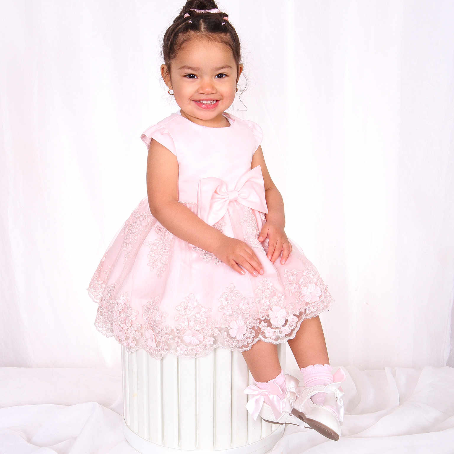 Zoey is registered to the contest to win money with this photo: bow, child, cute, earrings, elegant, fashion, girl, hairstyle, happy, innocent, lace, pink_dress, portrait, shoes, sitting, smiling, socks, studio_photo, toddler, white_background