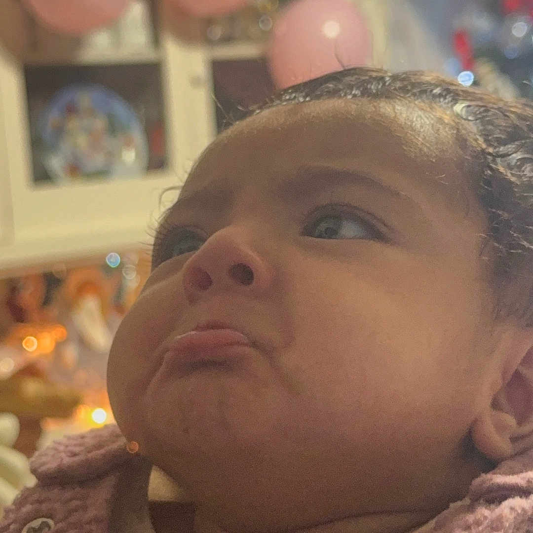 Aylani joined the competition — help win amazing prizes! baby, balloons, blurred_background, child, closeup, cute, expression, eyes, face, fuzzy, head, indoor, infant, nose, person, portrait, pout, purple_clothing, skin, texture