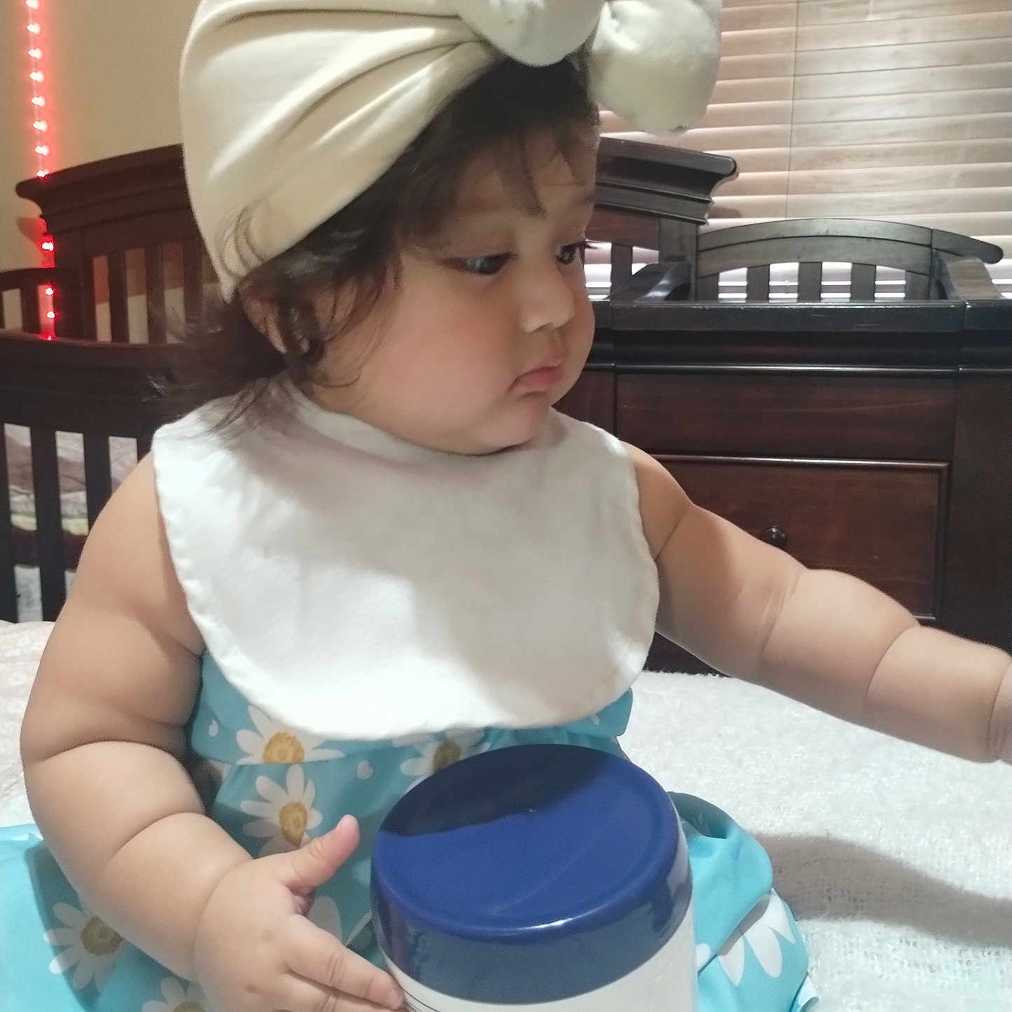 Sofia joined the competition — help win amazing prizes! baby, bodypart, bonnet, cap, clothing, costume, crib, dress, face, finger, food, furniture, hand, hat, head, indoors, infantbed, person, photography, portrait