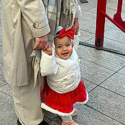Aliyah participe au concours pour gagner de l'argent avec cette photo : toddler, child, adult, holding_hands, red_bow, red_skirt, white_jacket, scarf, sidewalk, outdoor, footwear, happy, walking, person, pavement, winter_clothing, smiling, urban, family, support