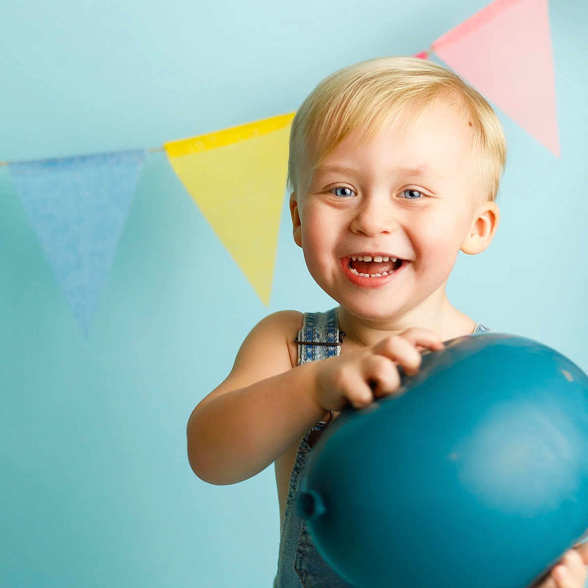 Walker is registered to the contest to win money with this photo: baby, balloon, blonde, bodypart, clothing, face, finger, hand, happy, head, jeans, laughing, mouth, pants, person, photography, portrait, smile, sphere, teeth