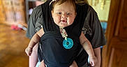 Hadleigh Rose joined the competition — help win amazing prizes! baby, baby_carrier, black_shirt, child, cute, decor, face, family, happy, holding, home_interior, indoor, pacifier, parenting, person, pink_pants, portrait, smiling, wooden_floor, wooden_furniture