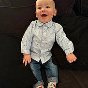 Maëlo participe au concours pour gagner de l'argent avec cette photo : baby, child, smiling, sitting, shirt, jeans, socks, couch, pillow, happy, indoor, portrait, cute, infant, clothing, person, face, hands, feet, casual