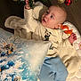Maëlo participe au concours pour gagner de l'argent avec cette photo : baby, blanket, blue_pants, child, christmas_tree, curious, cute, decorations, festive, floor, holiday, indoor, infant, ornaments, pajamas, pillow, reaching, smiling, soft_toys, white_shirt