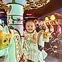 toddler, child, carousel, arcade, horse, ride, striped_dress, smiling, indoor, colorful_lights, amusement, playful, toy, entertainment, game_machines, person, fun, happy, decorative, family