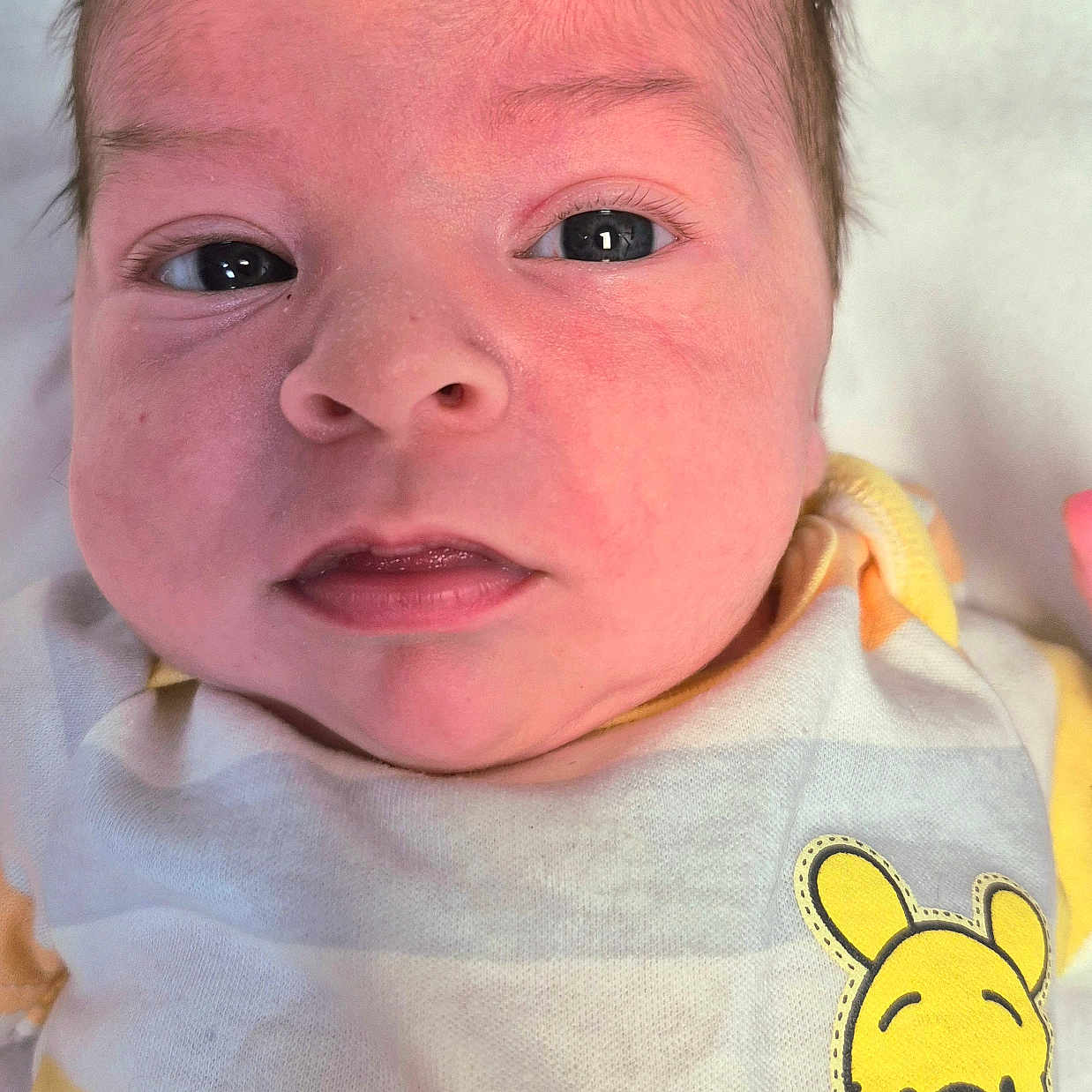 Braxton is registered to the contest to win money with this photo: baby, baby_outfit, child, closeup, clothing, cute, expression, eyes, face, head, infant, lying_down, mouth, newborn, patch, portrait, skin, soft, white, yellow