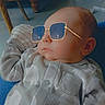 Liam joined the competition — help win amazing prizes! baby, child, sunglasses, onesie, elephant_pattern, indoor, furniture, chair, sofa, cute, infant, portrait, relaxed, casual, cozy, home, wooden_furniture, fashion, face, person