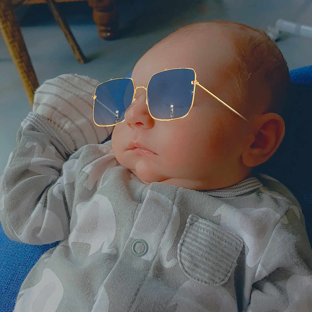 Liam joined the competition — help win amazing prizes! baby, child, sunglasses, onesie, elephant_pattern, indoor, furniture, chair, sofa, cute, infant, portrait, relaxed, casual, cozy, home, wooden_furniture, fashion, face, person