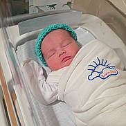 Theodore joined the competition — help win amazing prizes! newborn, baby, sleeping, hospital, bassinet, blanket, swaddled, knit_cap, turquoise, infant, portrait, face, closed_eyes, peaceful, nursery, name_card, theodore, dinosaur_pattern, medical_setting, cozy