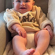 Weston is registered to the contest to win money with this photo: baby, smiling, sweater, knitwear, infant, happy, face, feet, cozy, chair, blanket, soft, cute, child, portrait, indoors, warm, relaxed, furniture, seated