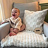 Weston joined the competition — help win amazing prizes! baby, smile, armchair, blanket, cushion, cozy, indoor, happy, child, milestone, soft_texture, wooden_sign, natural_light, window, curtain, sweater, foot, skin, person, portrait