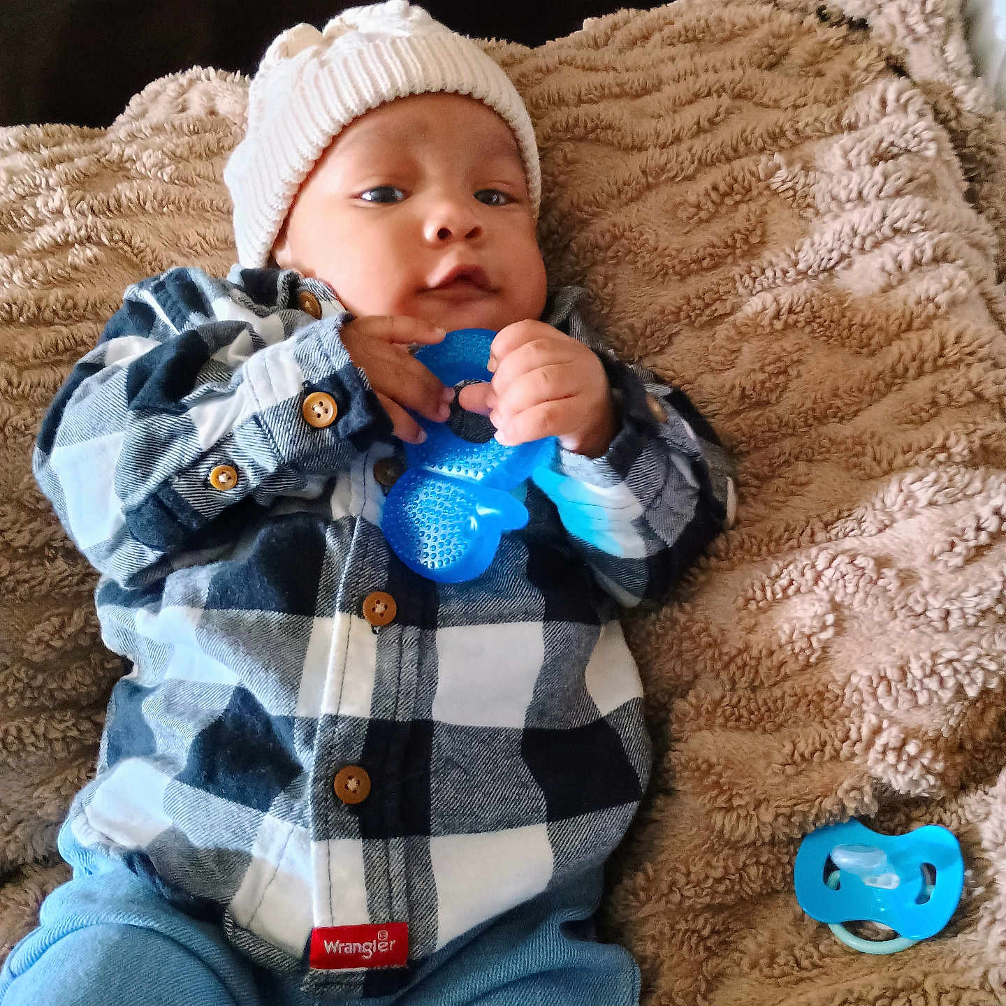 Khilan Lucas is registered to the contest to win money with this photo: baby, blanket, blue_teething_toy, buttoned_shirt, casual, child, clothing, cozy, cute, face, hands, indoor, infant, jeans, knit_hat, lying_down, pacifier, plaid_shirt, portrait, soft_texture