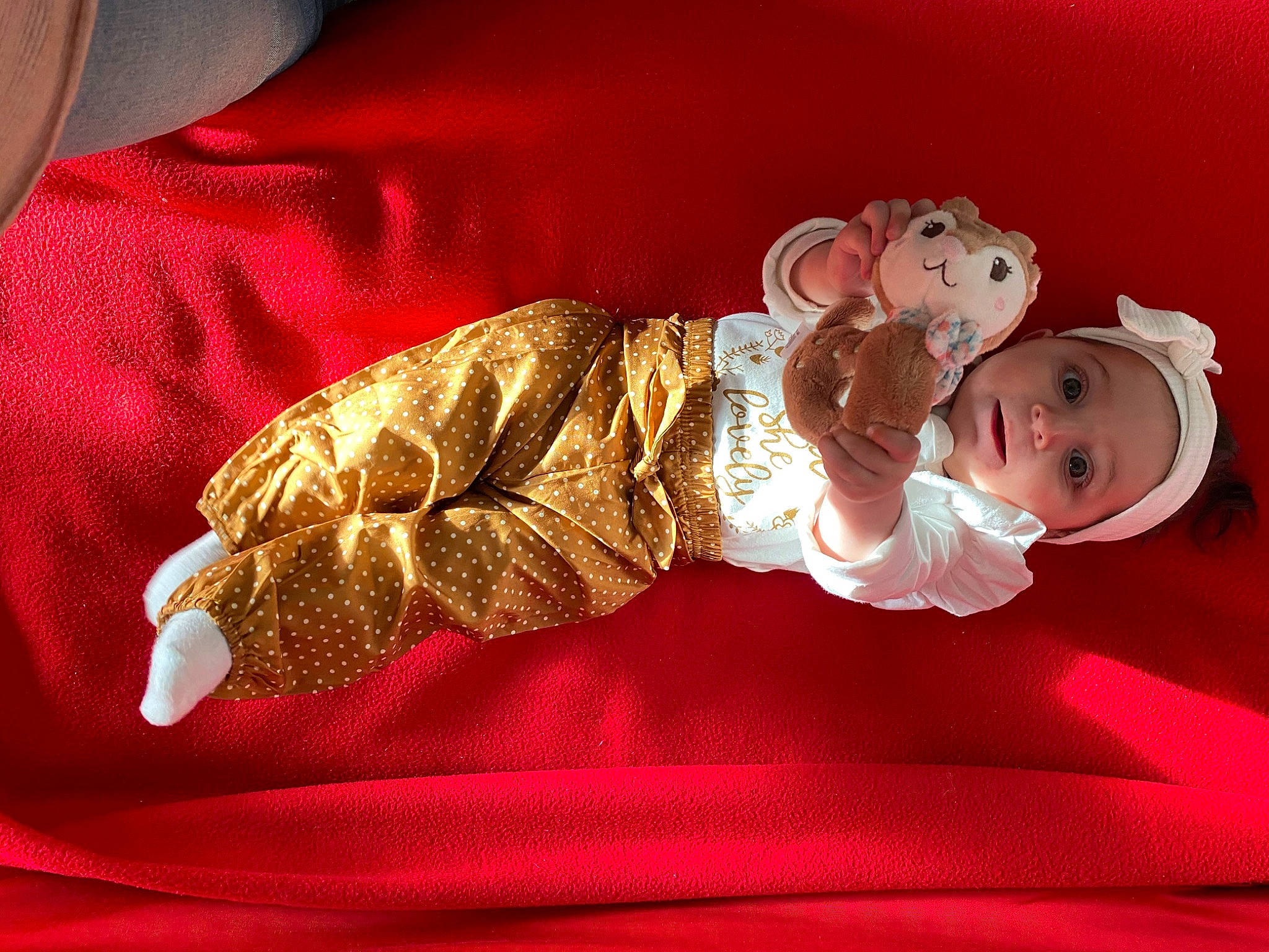 Mila participe au concours pour gagner de l'argent avec cette photo : baby, baby_products, baby_sleeping, baby_toddler_clothing, bedding, carmine, child, comfort, happy, hat, headwear, human_leg, linens, magenta, pattern, person, red, room, sitting, sleeve