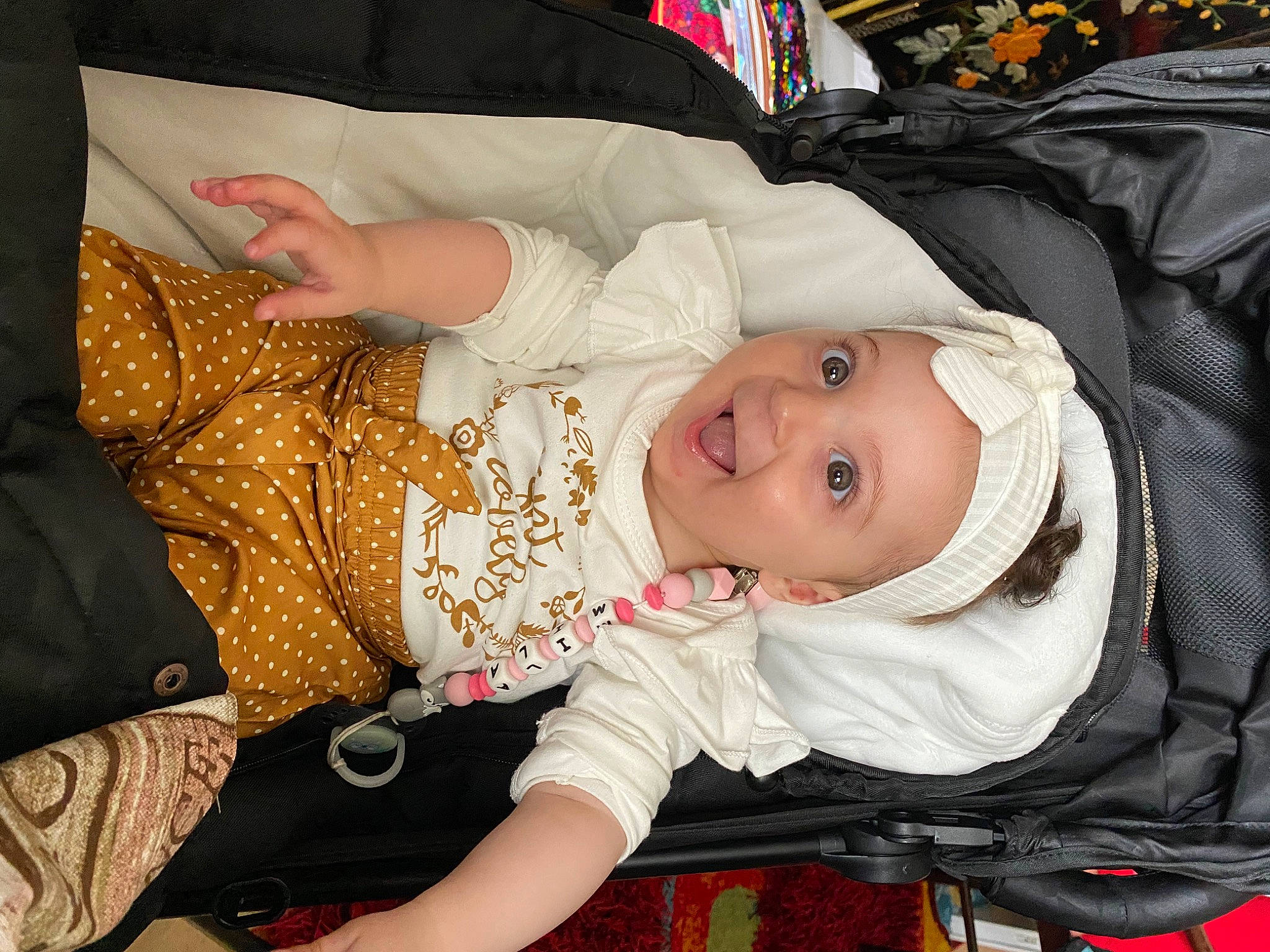 Mila a rejoint le concours — aidez-le/la à gagner de superbes lots ! baby, baby_carriage, baby_products, baby_safety, baby_toddler_clothing, cheek, child, comfort, eye, facial_expression, head, headwear, iris, lap, pattern, person, sitting, skin, sleeve, smile