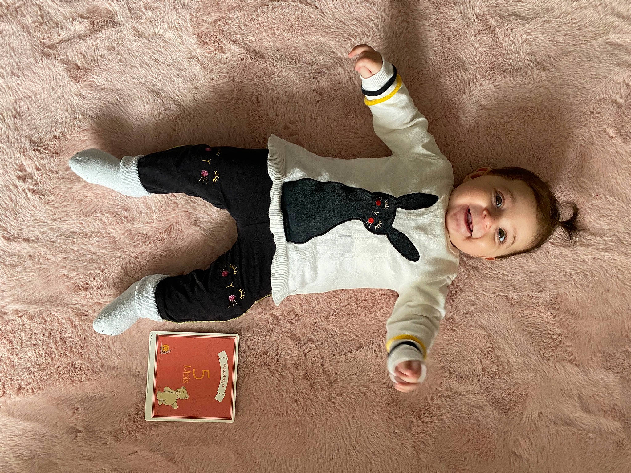 Mila participe au concours pour gagner de l'argent avec cette photo : baby, carmine, child, comfort, finger, flooring, font, fun, gesture, happy, landscape, pattern, people_in_nature, person, shadow, sitting, sleeve, thumb, toddler, vertebrate