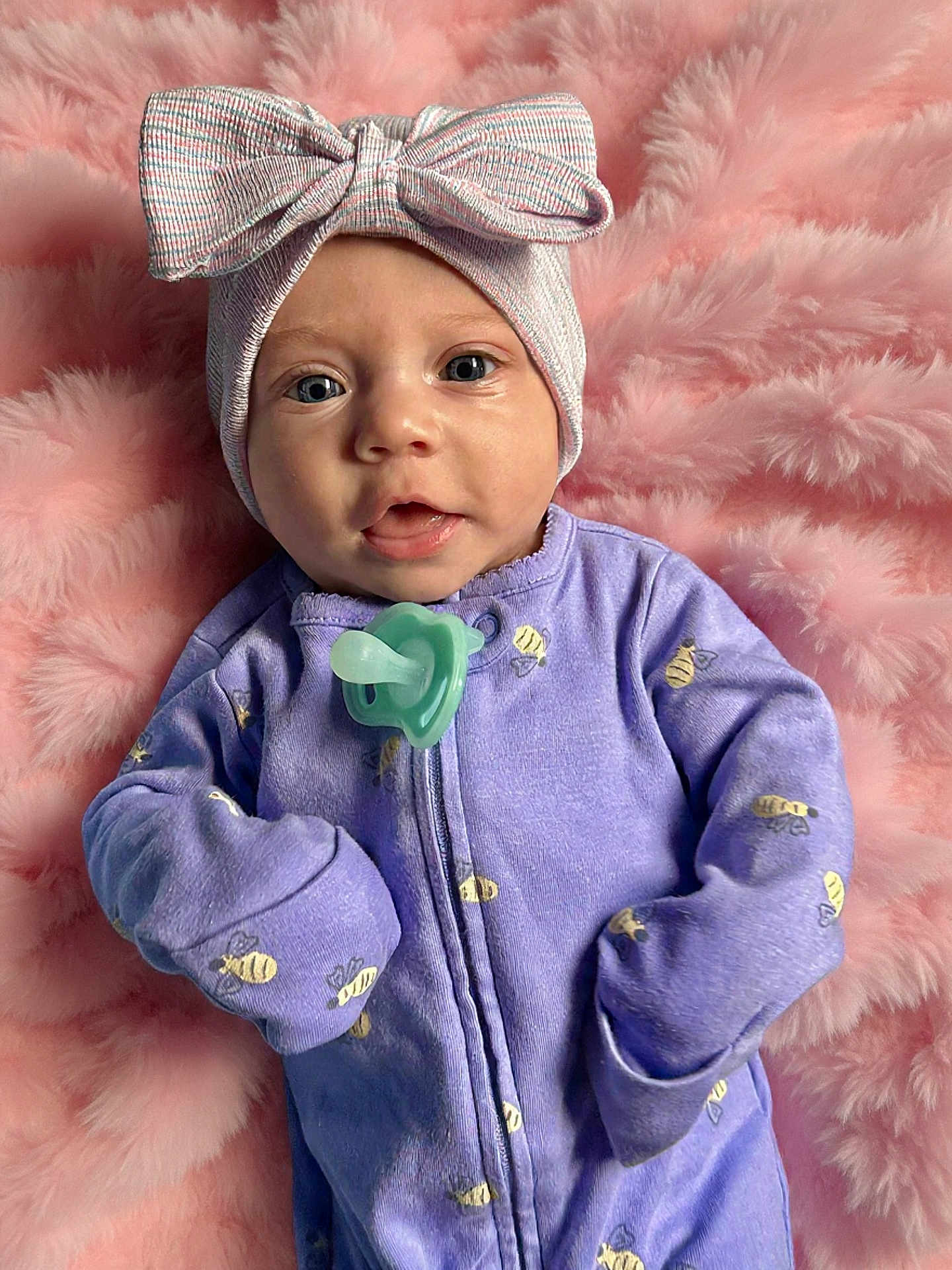 Oakley joined the competition — help win amazing prizes! baby, infant, child, onesie, headband, bow, pacifier, purple_clothing, pink_blanket, fluffy, cute, portrait, face, eyes, mouth, hand, soft_texture, sleepwear, resting, indoors