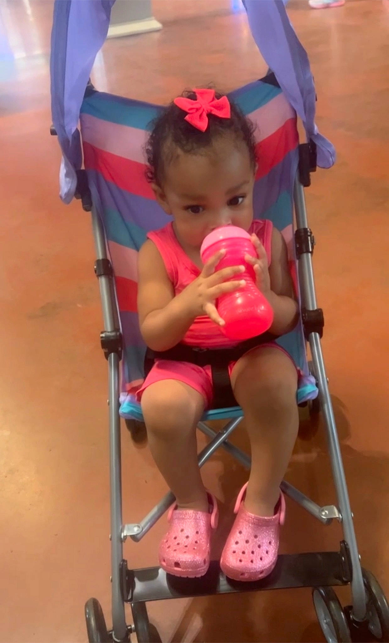 Jaylee is registered to the contest to win money with this photo: baby, baby_carriage, baby_products, baby_toddler_clothing, child, chin, foot, fun, human_leg, leisure, magenta, person, pink, recreation, red, sitting, skin, thigh, tire, toddler