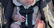 Athena is registered to the contest to win money with this photo: baby, child, infant, sleeping, stroller, bonnet, hat, white_clothing, harness, socks, outdoor, portrait, seated, sunlight, face, hands, legs, baby_carriage, nap, adorable