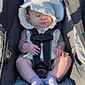 baby, child, infant, sleeping, stroller, bonnet, hat, white_clothing, harness, socks, outdoor, portrait, seated, sunlight, face, hands, legs, baby_carriage, nap, adorable