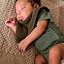 baby, sleeping, infant, blanket, green_onesie, socks, curly_hair, peaceful, resting, soft_texture, cozy, child, indoors, cute, portrait, newborn, relaxing, toddler, skin, hand