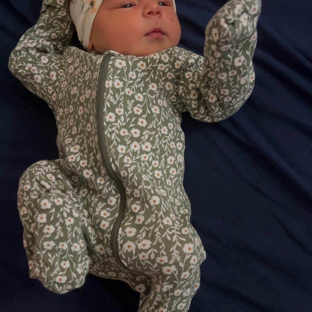 Ariah is registered to the contest to win money with this photo: baby, bodypart, bonnet, cap, clothing, couch, dress, face, finger, furniture, glove, hand, hat, head, longsleeve, newborn, person, photography, portrait, sleeve