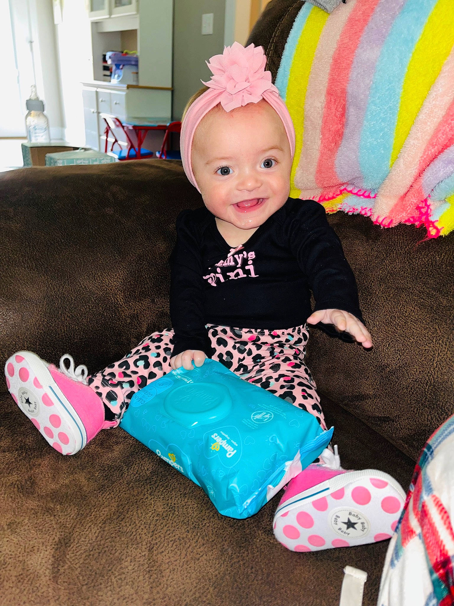 Addison is registered to the contest to win money with this photo: baby, baby_products, baby_toddler_clothing, child, comfort, couch, fashion_accessory, happy, linens, magenta, pattern, person, pink, room, sitting, sleeve, smile, sock, t_shirt, textile