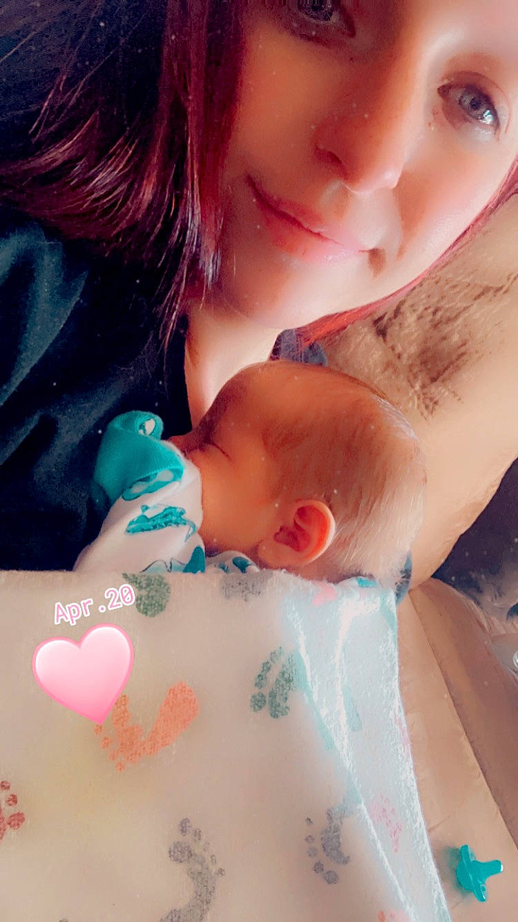 Asher is registered to the contest to win money with this photo: arm, baby, cheek, eyelash, face, finger, gesture, hand, happy, human_body, interaction, joint, lip, mouth, nail, neck, nose, person, red, shoulder