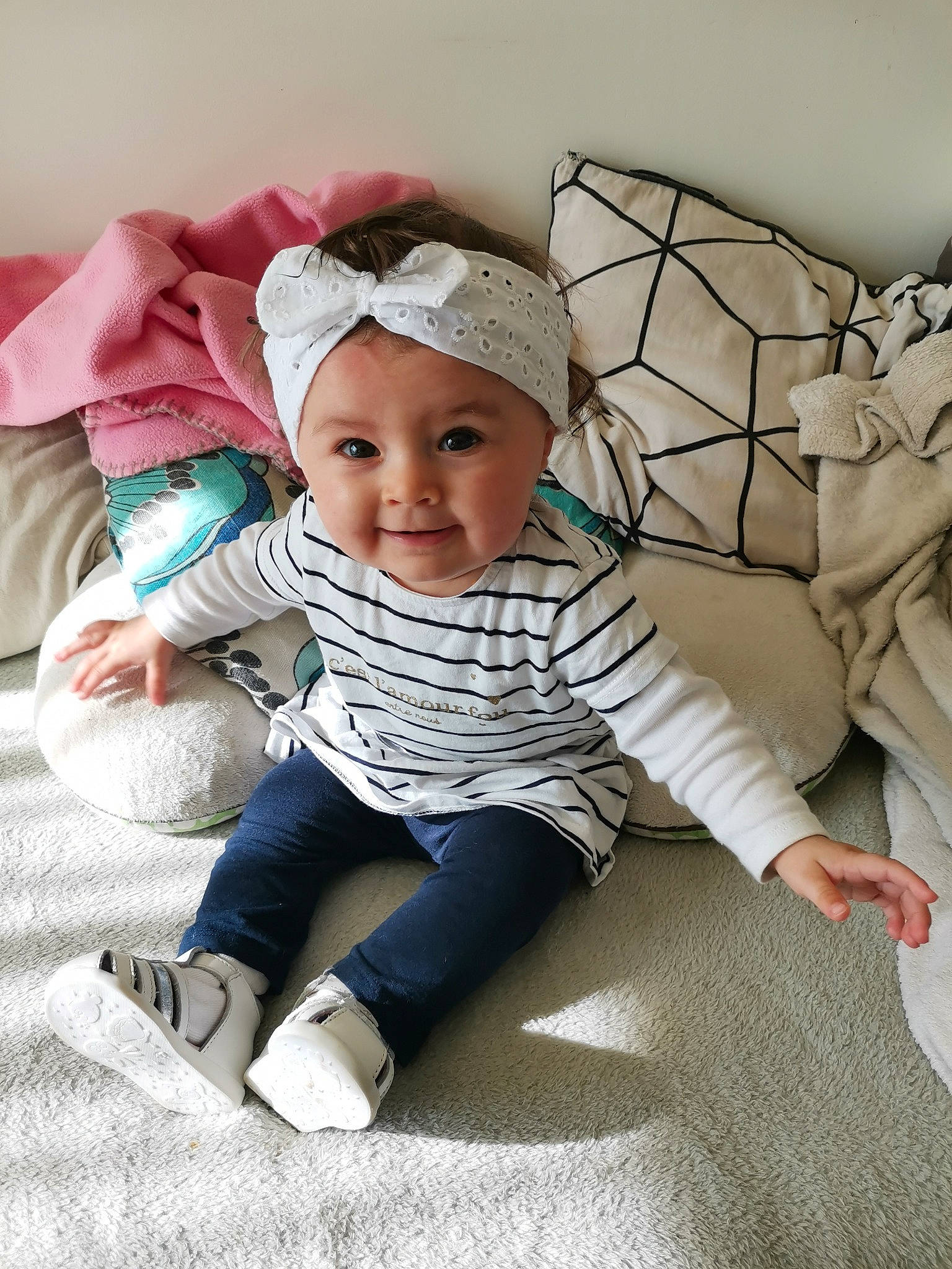 Taïs a rejoint le concours — aidez-le/la à gagner de superbes lots ! baby, baby_toddler_clothing, cap, child, comfort, eye, fashion_accessory, flooring, fun, grass, happy, headwear, joy, linens, pattern, person, sitting, skin, sleeve, smile