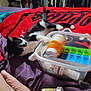 Mia joined the competition — help win amazing prizes! bed, black_and_white_cat, blanket, cat, clothing, container, foot, furniture, indoor, medicine, paw, pet, pill_bottle, pills, plastic_container, playful, purple_blanket, red_blanket, relaxing, tattoo