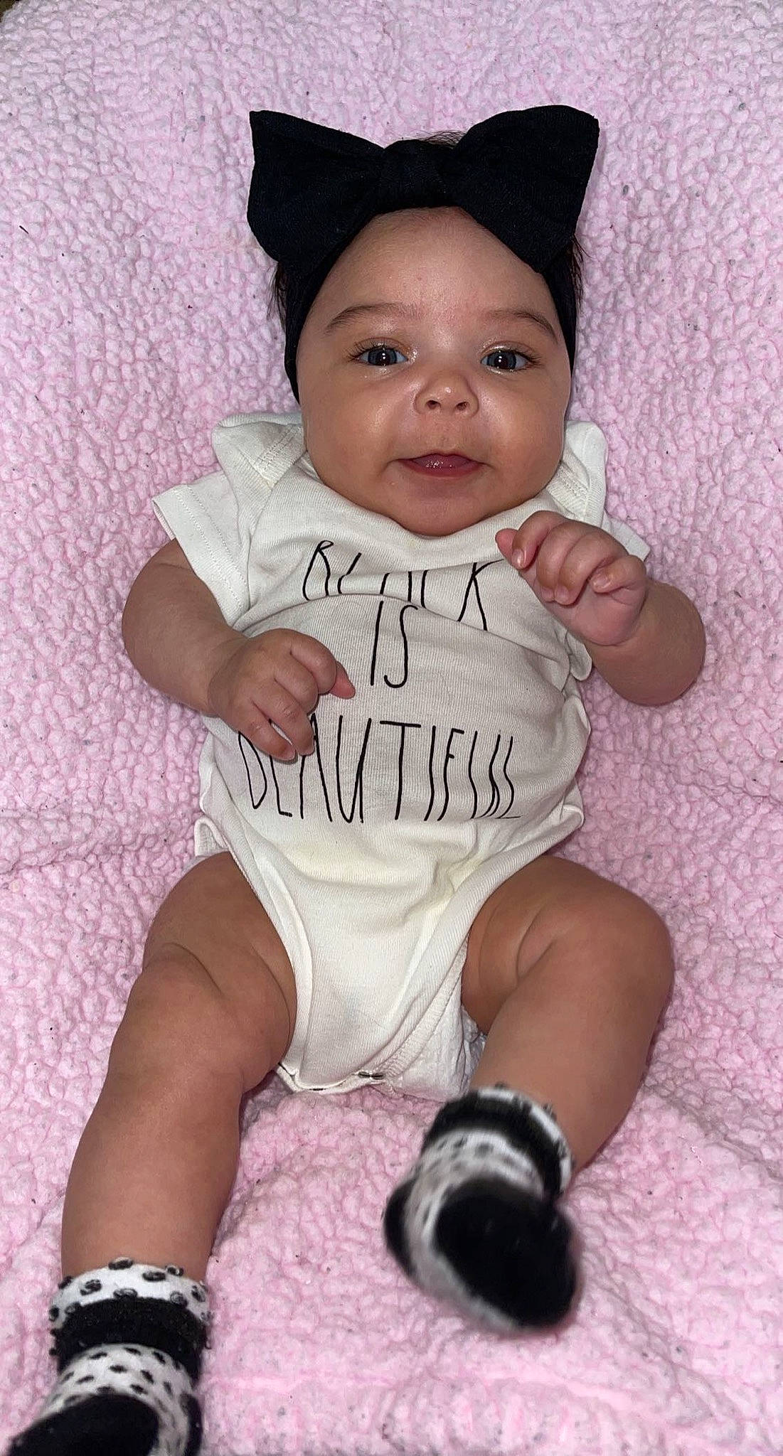 Indigo is registered to the contest to win money with this photo: baby, baby_toddler_clothing, cheek, eye, face, facial_expression, gesture, hand, happy, head, human_body, leg, person, pink, purple, skin, sleeve, smile, t_shirt, textile