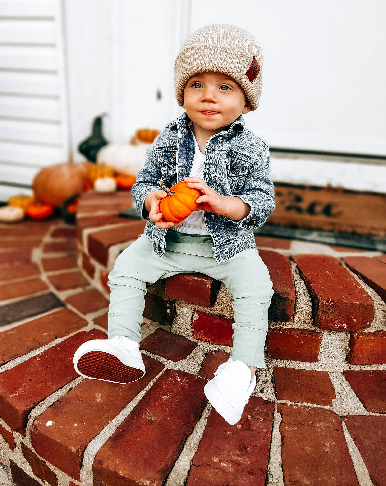 Levi is registered to the contest to win money with this photo: baby, baby_toddler_clothing, boot, brick, brickwork, cap, child, face, flash_photography, floor, flooring, footwear, happy, headwear, orange, person, shoe, sitting, sleeve, smile