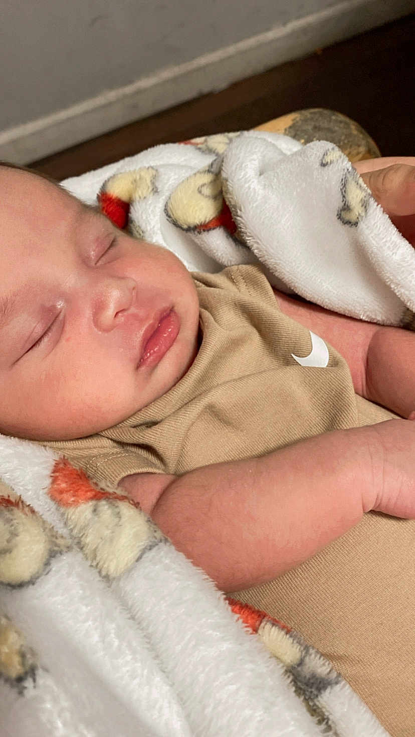 Dylan is registered to the contest to win money with this photo: baby, sleeping, blanket, infant, peaceful, closeup, soft, cozy, skin, face, arm, clothing, newborn, rest, indoors, toddler, cute, portrait, comfort, relaxation