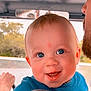 Kohen is registered to the contest to win money with this photo: baby, child, blue_eyes, smiling, happy, face, person, infant, cute, portrait, indoors, closeup, parent, holding, vehicle, seat, clothing, young, head, expression