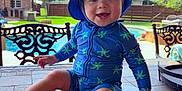 Kohen joined the competition — help win amazing prizes! baby, child, smiling, swimsuit, hat, blue, starfish, outdoor, pool, table, tile, sunny, backyard, chair, greenery, happy, sitting, person, summer, playful