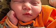 Kaëlya participe au concours pour gagner de l'argent avec cette photo : baby, sleeping, infant, orange_clothing, cute, peaceful, hand, face, resting, soft, closeup, portrait, newborn, child, skin, indoors, blanket, comfort, young, adorable