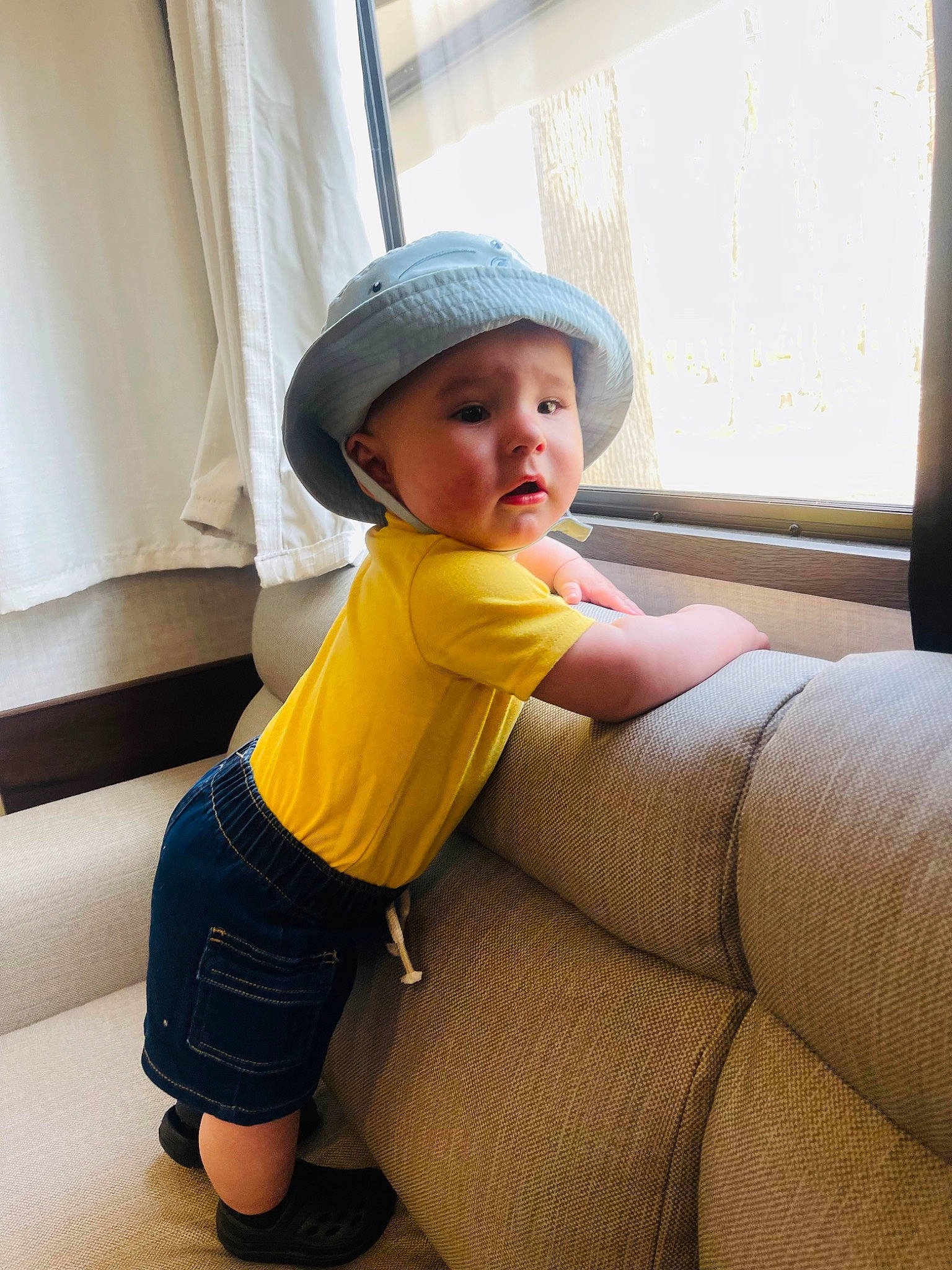 Jaxson is registered to the contest to win money with this photo: baby, baby_toddler_clothing, cap, car_seat, child, comfort, fashion_accessory, flooring, fun, hat, headwear, human_leg, knee, leg, person, personal_protective_equipment, sitting, sleeve, t_shirt, thigh