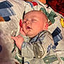 baby, sleeping, onesie, car_pattern, blanket, cozy, infant, child, cute, soft, peaceful, resting, toddler, indoor, portrait, clothing, hand, face, nap, comfort