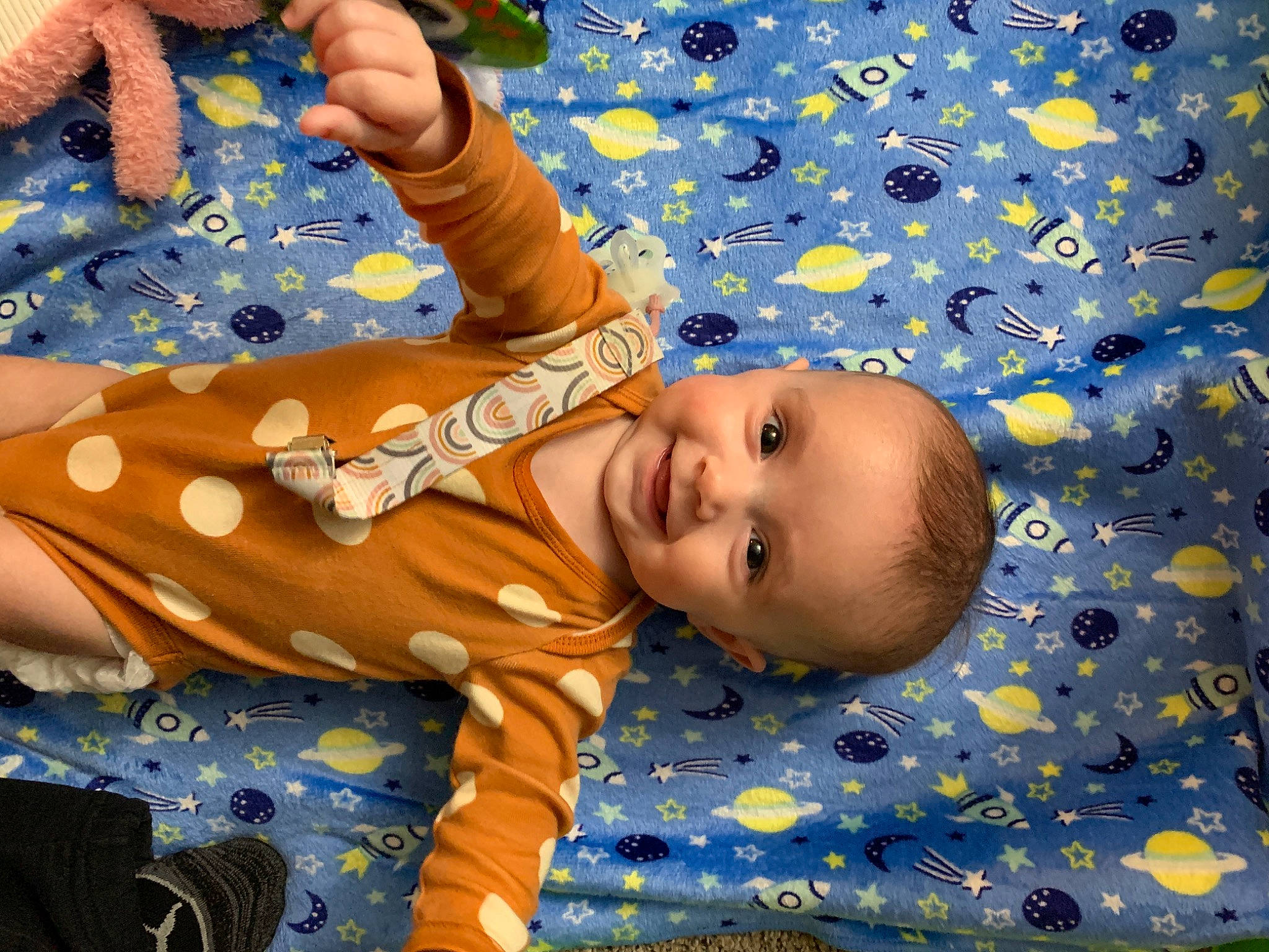 Nova is registered to the contest to win money with this photo: arm, baby, baby_products, baby_toddler_clothing, cheek, chest, child, electric_blue, fun, gesture, happy, joy, leisure, linens, nail, pattern, people_in_nature, person, smile, thumb