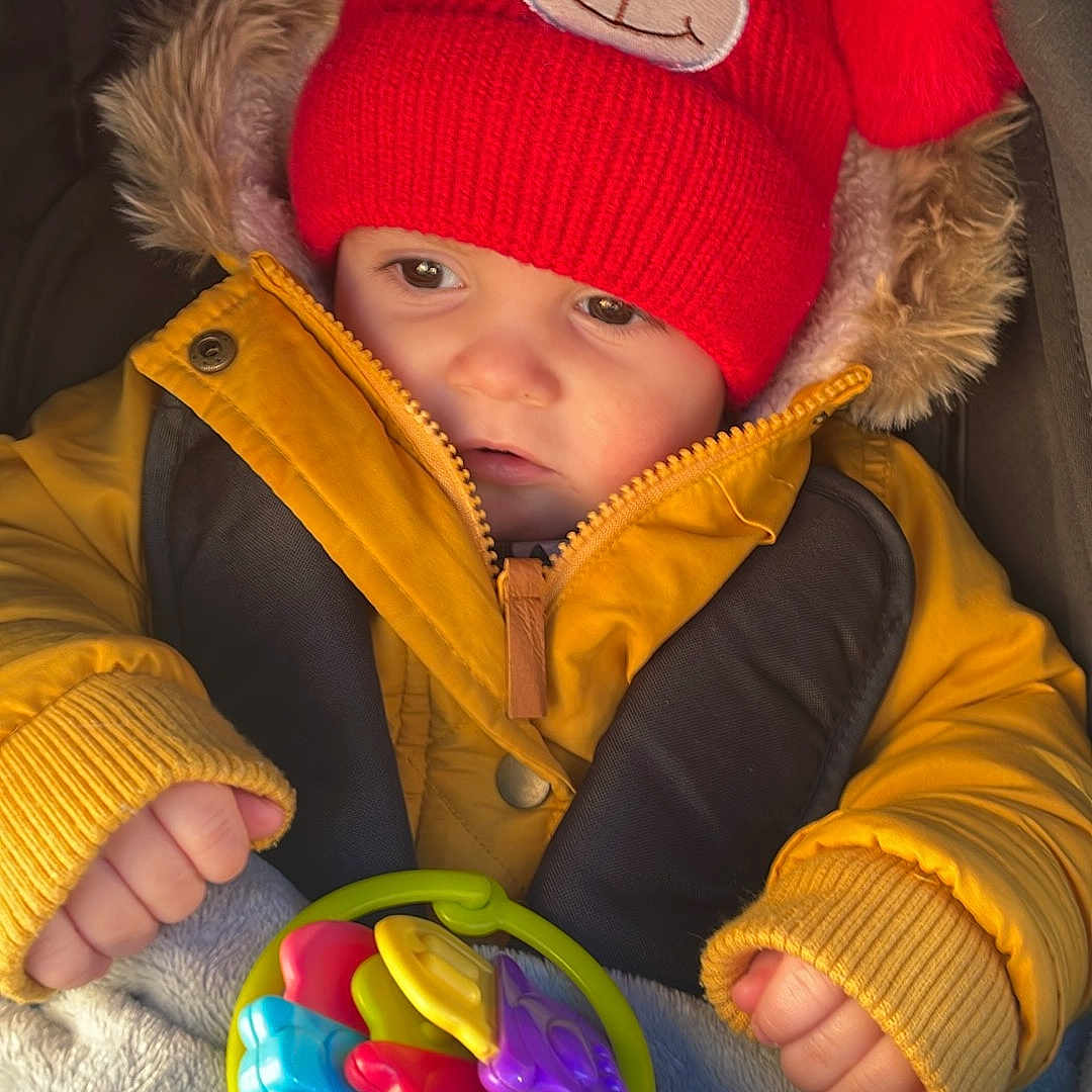 Tiago participe au concours pour gagner de l'argent avec cette photo : baby, beanie, bodypart, bonnet, cap, clothing, coat, face, finger, glove, hand, hat, head, hood, jacket, knitwear, person, photography, portrait, sweater
