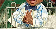 Zion is registered to the contest to win money with this photo: toddler, child, shopping_cart, bow_tie, plaid_shirt, clapping, smiling, happy, indoor, lights, wood_floor, baby, person, cute, fashion, seated, retail, store, clothing, footwear