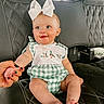 Oaklynn is registered to the contest to win money with this photo: baby, child, toddler, bow, green_checkered_clothing, holding_hand, car_seat, black_leather, quilted_pattern, drool, smiling, sitting, cute, infant, person, hand, fingers, indoors, headband, face