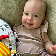 Daphne is registered to the contest to win money with this photo: baby, babylaughing, bodypart, couch, cushion, face, finger, furniture, hand, happy, head, homedecor, laughing, linen, newborn, person, photography, portrait, sitting, smile