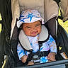 baby, smiling, child, stroller, hat, starfish_pattern, outdoor, sunny, seatbelt, clothing, happy, infant, cute, babygear, headwear, person, portrait, babyface, sitting, babyclothes