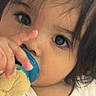 child, baby, face, eyes, hand, pacifier, toy, plush, closeup, infant, cute, soft_lighting, portrait, expression, young_child, hair, skin, clothing, indoors, comfort