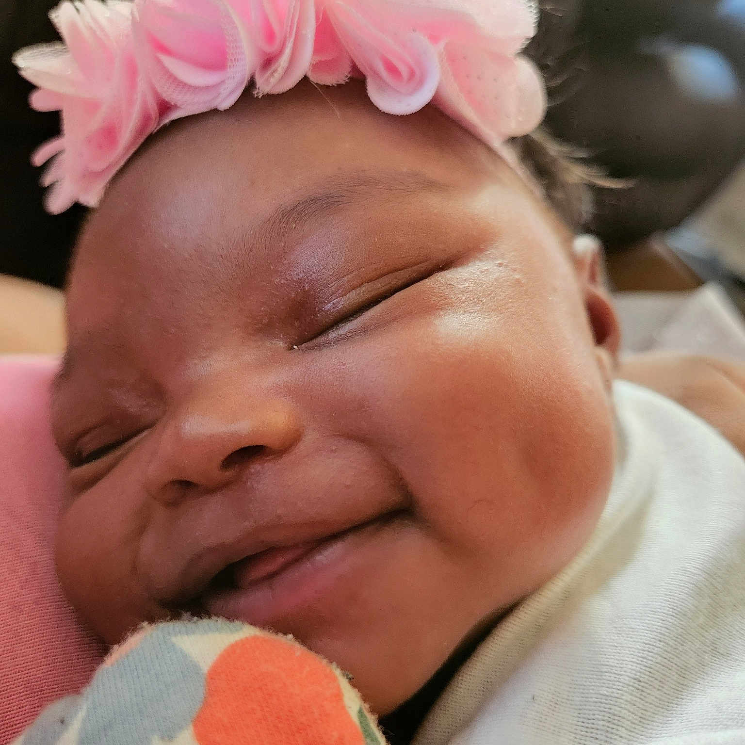 Tessa is registered to the contest to win money with this photo: baby, cheek, chin, eyebrow, eyelash, face, facial_expression, finger, forehead, gesture, hairstyle, happy, headgear, lip, mouth, nose, pink, skin, smile, textile